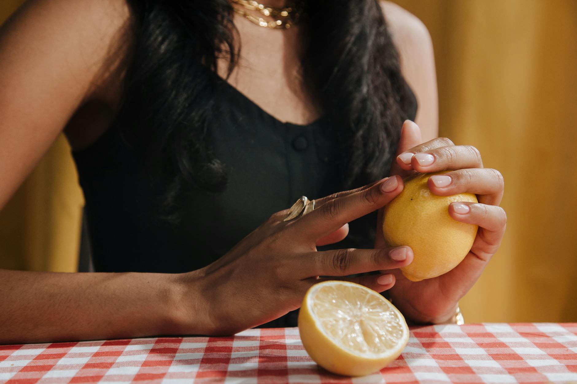 A close-up view of a hand holding a blue vibrator above a decorative glass bowl, symbolizing gentle control and intentional self-care.