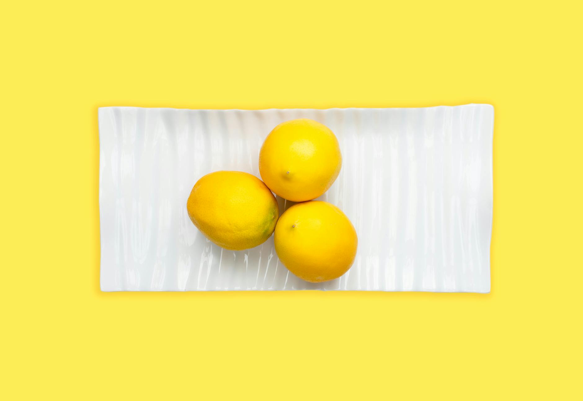 Diversos vibradores de colores brillantes organizados sobre una superficie amarilla vibrante, mostrando diseño y variedad