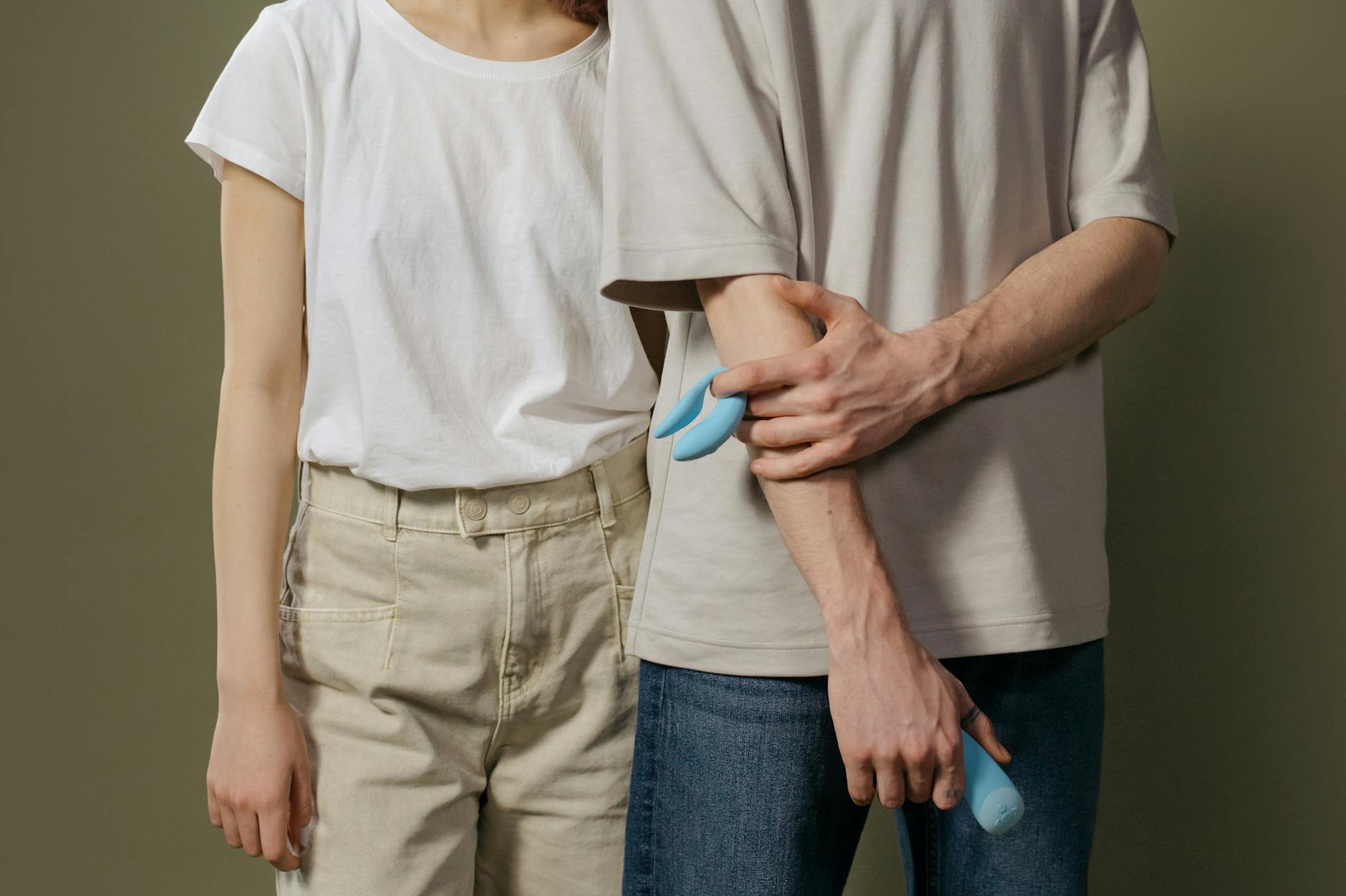 Pareja joven sosteniendo un vibrador azul juntos, simbolizando la intimidad moderna compartida